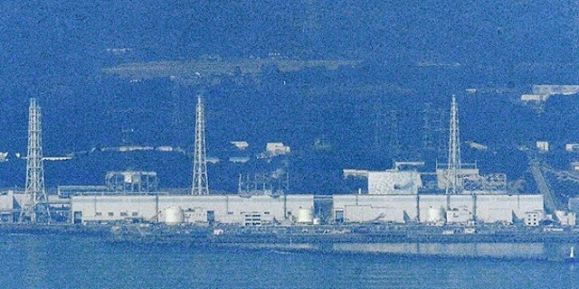 March 29: Only Unit 2 is covered with white concrete housing, seen on left of an iron tower on right, at the stricken Fukushima Dai-ichi nuclear power plant in Okumamachi, Fukushima prefecture.