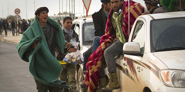 March 29: Libyan rebels run with their belongings as they leave Ras Lanouf, 250 km east of Sirte, central Libya.