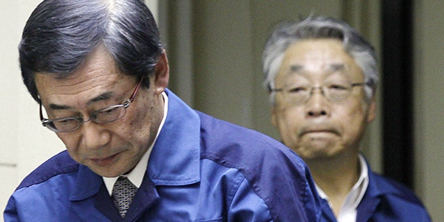 March 13: Masataka Shimizu, president of Tokyo Electric Power Co., left, and Executive Vice President Takashi Fujimoto, right, enter the venue of the press conference in Tokyo, Japan.