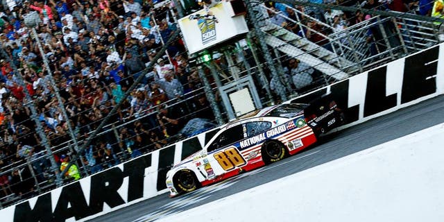 MARTINSVILLE, VA - OCTOBER 26: Dale Earnhardt Jr., driver of the #88 National Guard Chevrolet, takes the checkered flag to win the NASCAR Sprint Cup Series Goody's Headache Relief Shot 500 at Martinsville Speedway on October 26, 2014 in Martinsville, Virginia. (Photo by Jeff Zelevansky/Getty Images)