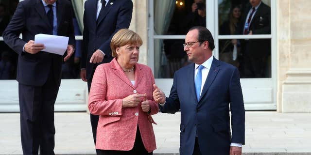 France's President Francois Hollande, right, and German Chancellor Angela Merkel arrive to pose for a family photo during the Balkans summit, at the Elysee Palace, in Paris, Monday, July 4, 2016.The leaders of France, Germany, Italy and Balkan nations are meeting to better prevent extremists from sneaking in with migrants who are moving west across Europe. (AP Photo/Thibault Camus, Pool)