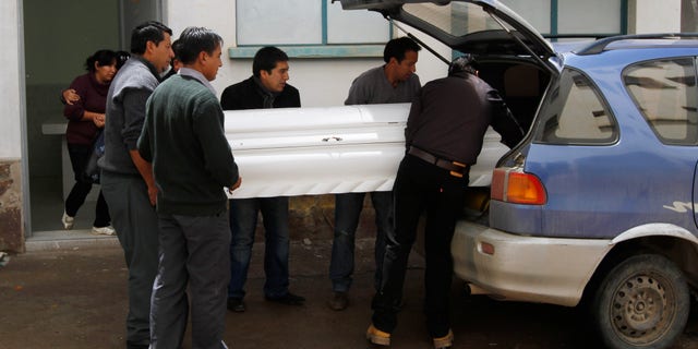 Relatives place the coffin containing the remains of Kevin Beltran Estrada, who died after an explosive went off during a soccer game, into a car in Oruro, Bolivia, Thursday, Feb. 21, 2013. Twelve Corinthian soccer fans were arrested on suspicion of having caused the death of a 14-year-old San Jose soccer fan by launching an explosive device during a Copa Libertadores game between San Jose and Corinthians on Wednesday in the Bolivian city of Oruro, according to police. (AP Photo/Juan Karita)