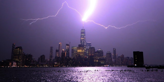 Lightning lights up the sky over Lower Manhattan as a bolt strikes One World Trade Center on Aug. 22, 2017, as seen from Hoboken, New Jersey.