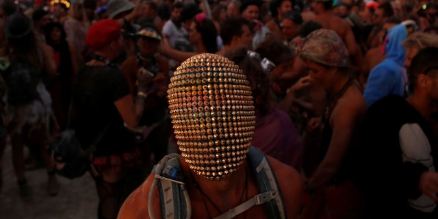 A participant wears a mask as he dances as approximately 70,000 people from all over the world gathered for the annual Burning Man arts and music festival in the Black Rock Desert of Nevada, U.S. August 29, 2017.