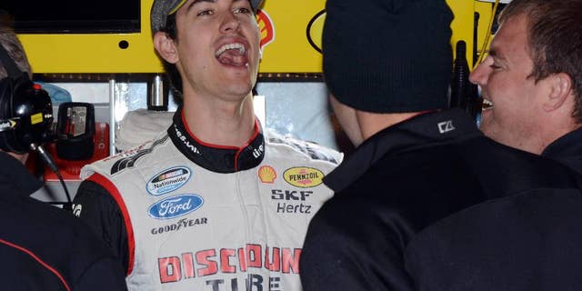 Driver Joey Logano shares a laugh with his crew in the garage during practice for Sunday's NASCAR Sprint Cup series auto race at the Texas Motor Speedway in Fort Worth, Texas, Saturday, Nov. 1, 2014. (AP Photo/Larry Papke)