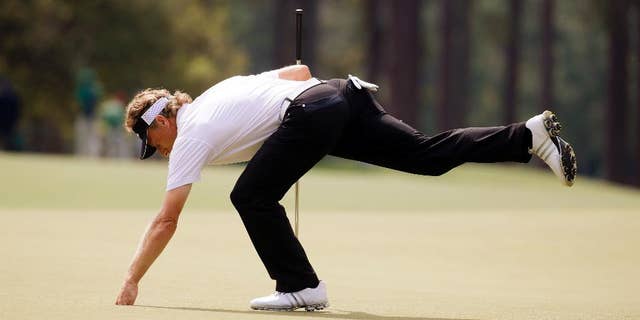 Bernhard Langer, of Germany, gets his ball out of the cup after putting on the eighth green during the second round of the Masters golf tournament Friday, April 11, 2014, in Augusta, Ga. (AP Photo/Darron Cummings)