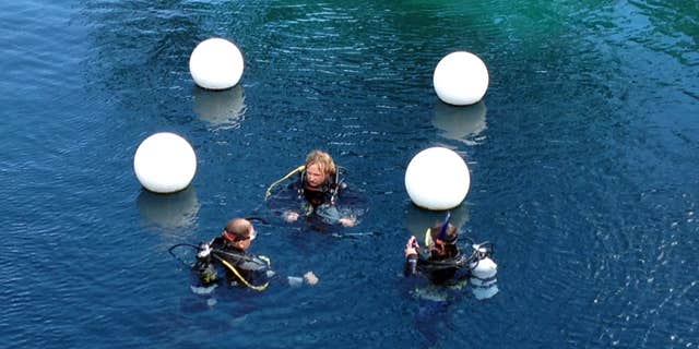 FILE - This June 6, 2015 file photo shows divers at Blue Hole State Park in Santa Rosa, N.M.
