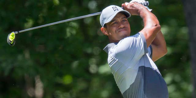 FILE - In this Saturday, Aug. 22, 2015 file photo, Tiger Woods tees off on the second hole during the third round of the Wyndham Championship golf tournament at Sedgefield Country Club in Greensboro, N.C.