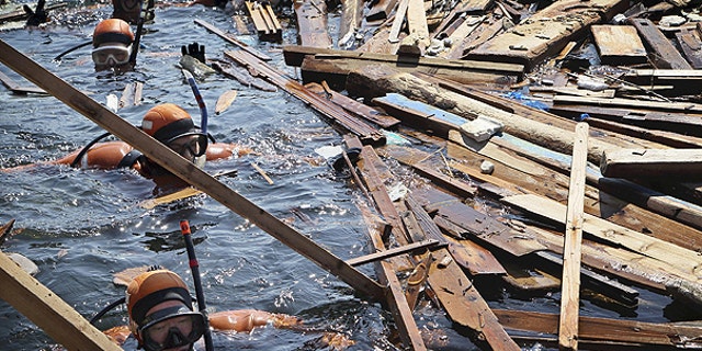April 5: Scuba divers search for the bodies of missing people in water of Yoriiso fishing port in Ishinomaki, Miyagi Prefecture following the March 11 earthquake and tsunami hit northeastern Japan.