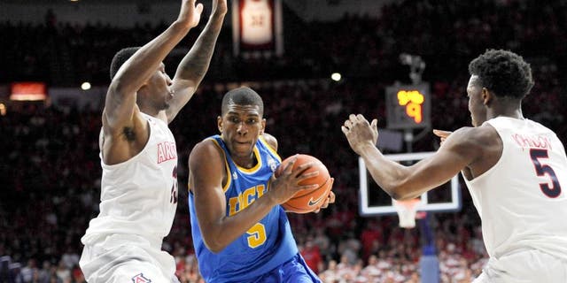 Feb 21, 2015; Tucson, AZ, USA; UCLA Bruins forward Kevon Looney (5) drives to the basket as he is defended by Arizona Wildcats forward Rondae Hollis-Jefferson (23) and forward Stanley Johnson (5) during the first half at McKale Center. Mandatory Credit: Casey Sapio-USA TODAY Sports