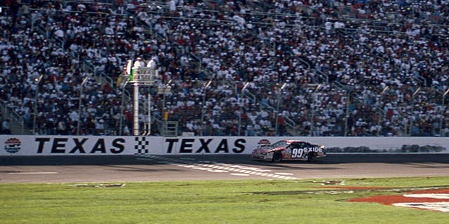 FORT WORTH, TX April 6, 1997: Jeff Burton takes the checkered flag to win the Interstate Batteries 500, the first NASCAR Cup race to be held at the new Texas Motor Speedway. (Photo by ISC Images & Archives via Getty Images)