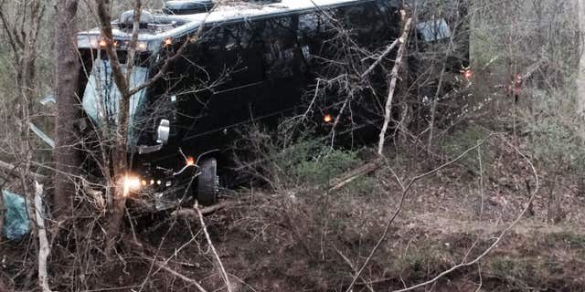 A tour bus for musician Gregg Allman's band rests against a tree near a creek after veering off Interstate 77 Wednesday morning, April 6, 2016, near Goldtown, W.Va.
