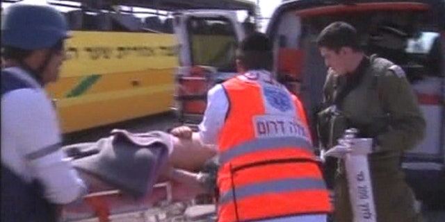 April 7: An injured person is loaded into an ambulance after a Palestinian mortar strikes an Israeli bus.