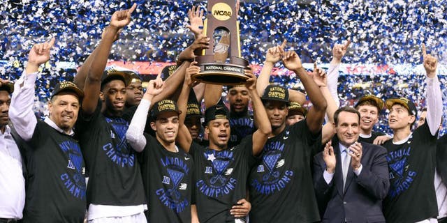 Apr 6, 2015; Indianapolis, IN, USA; Duke Blue Devils celebrate with the NCAA trophy on the podium after defeating the Wisconsin Badgers 68-63 in the 2015 NCAA Men's Division I Championship game at Lucas Oil Stadium. Mandatory Credit: Robert Deutsch-USA TODAY Sports