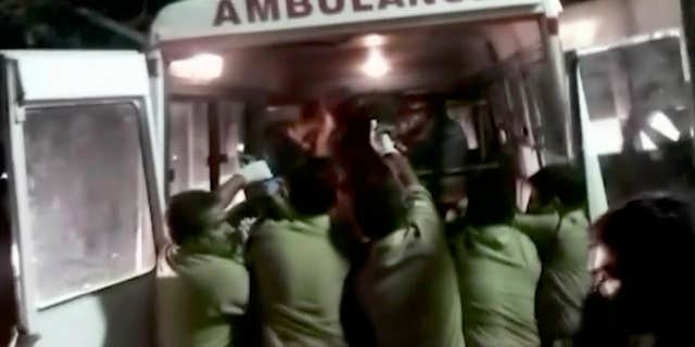 April 10, 2016: In this image made from video, officials put an injured person into an ambulance following a fire at a temple in Kollam, in the southern Indian state of Kerala.