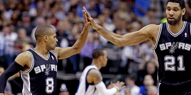 San Antonio Spurs guard Patty Mills (8) receives congratulations from Tim Duncan (21) during the second half an NBA basketball game against the Dallas Mavericks on Thursday, April 10, 2014, in Dallas. The Spurs won 109-100. (AP Photo/LM Otero)