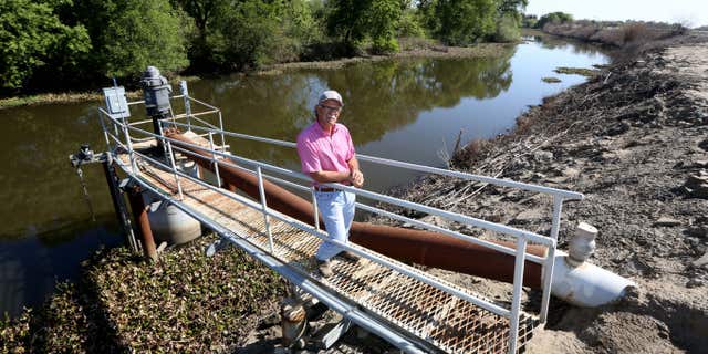 March 27, 2015: Farmer Rudy Mussi poses at one of his pumps that draws water from a slough to irrigate his farm land in the Sacramento-San Joaquin Delta near Stockton, Calif.