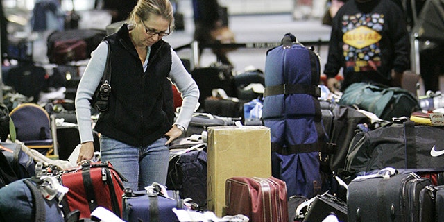 In this Feb. 20, 2007 file photo, Carolann Manfredi, of Princeton, N.J., searches through luggage for a bag she says has been missing for five days, at the Philadelphia International Airport. AP