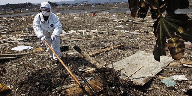 April 13: A police officer in protective suit searches for missing people in Minami Soma, Fukushima Prefecture, northeastern Japan.
