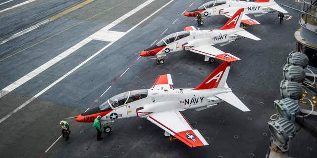 FILE - In this Dec. 10, 2016 file photo, pilots perform pre-flight procedures in T-45C Goshawks from Training Air Wing One on the flight deck of the aircraft carrier USS George Washington docked in Norfolk, Va.
