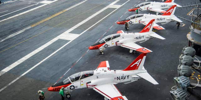 FILE - In this Dec. 10, 2016 file photo, pilots perform pre-flight procedures in T-45C Goshawks from Training Air Wing One on the flight deck of the aircraft carrier USS George Washington docked in Norfolk, Va.