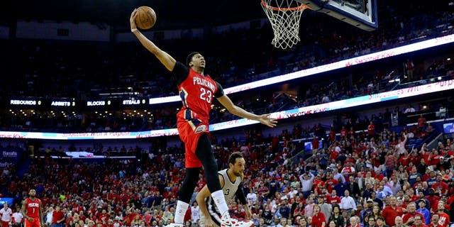 Apr 15, 2015; New Orleans, LA, USA; New Orleans Pelicans forward Anthony Davis (23) dunks over San Antonio Spurs forward Marco Belinelli (3) during the first quarter of a game at the Smoothie King Center. Mandatory Credit: Derick E. Hingle-USA TODAY Sports