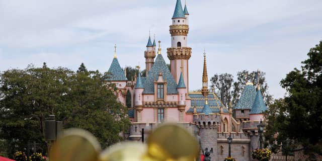 Jan. 22, 2015: In this file photo, people walk toward Sleeping Beauty's Castle at Disneyland in Anaheim, Calif.