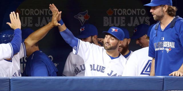 TORONTO, CANADA - APRIL 15: Kevin Pillar #11 of the Toronto Blue Jays is congratulated by teammates after making a leaping catch in the seventh inning during an MLB game against the Tampa Bay Rays on April 15, 2015 at Rogers Centre in Toronto, Ontario, Canada. All uniformed team members are wearing jersey number 42 in honor of Jackie Robinson Day. (Photo by Tom Szczerbowski/Getty Images)
