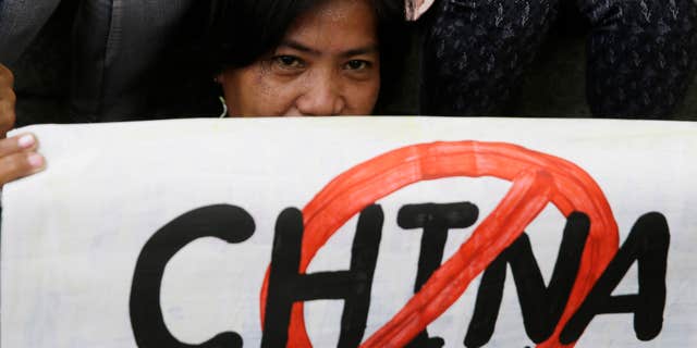 April 17, 2015: A protester displays a placard during a rally at the Chinese Consulate at the financial district of Makati city, east of Manila, Philippines.