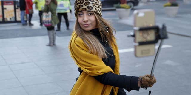 Jan. 8, 2015: Sandy Johal uses a selfie stick to take a picture of herself in New York's Times Square.