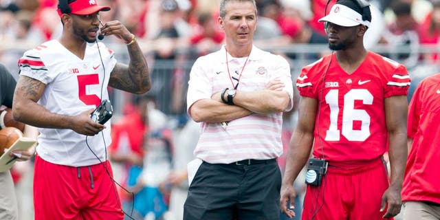 Apr 18, 2015; Columbus, OH, USA; Ohio State Buckeyes quarterback Braxton Miller (5) head coach Urban Meyer and quarterback J.T. Barrett (16) talk on the field during the Ohio State Spring Game at Ohio Stadium. The Gray team won the game 17-14. Mandatory Credit: Greg Bartram-USA TODAY Sports