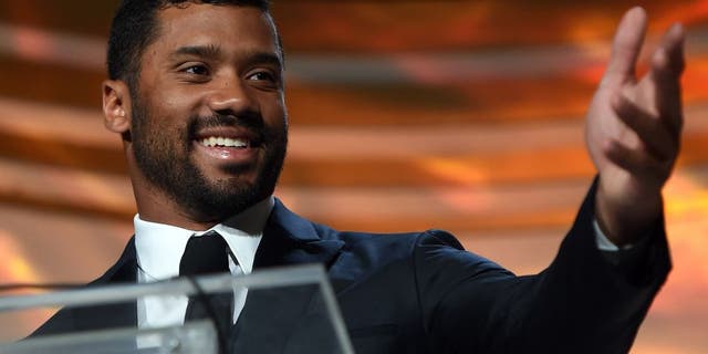 PHOENIX, AZ - MARCH 28: Seattle Seahawks quarterback Russell Wilson accepts an award during Muhammad Ali's Celebrity Fight Night XXI at the JW Marriott Phoenix Desert Ridge Resort & Spa on March 28, 2015 in Phoenix, Arizona. (Photo by Ethan Miller/Getty Images for Celebrity Fight Night)