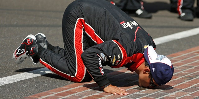 Juan Pablo Montoya, of Colombia, kisses the start/finish line after winning the 99th running of the Indianapolis 500 auto race at Indianapolis Motor Speedway in Indianapolis, Sunday, May 24, 2015. (AP Photo/Rob Baker)
