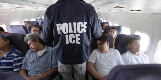 May 25, 2010: An Immigration and Customs Enforcement agent walks down the aisle among shackled Mexican immigrants a boarded a U.S. Immigration and Customs Enforcement charter jet for deportation in the air between Chicago, Il.