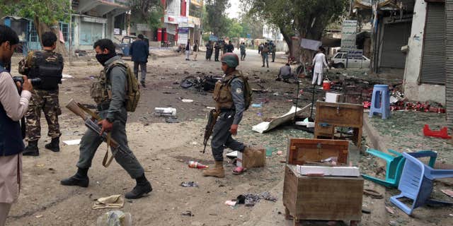 April 18, 2015: Afghan security forces members inspect the site of a suicide attack near a new Kabul Bank in Jalalabad, east of Kabul, Afghanistan.