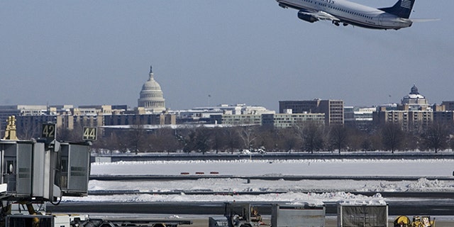 In this Feb. 8, 2010 file photo, with the U.S. Capitol in the background, a US Airways plane takes off from Washington's Reagan National Airport.
