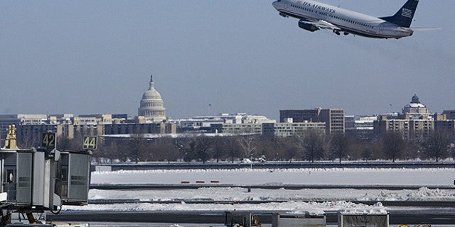 In this Feb. 8, 2010 file photo, with the U.S. Capitol in the background, a US Airways plane takes off from Washington's Reagan National Airport.
