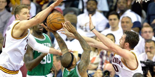Apr 19, 2015; Cleveland, OH, USA; Boston Celtics guard Isaiah Thomas (4) drives between Cleveland Cavaliers center Timofey Mozgov (20) and forward Kevin Love (0) in the third quarter in game one of the first round of the NBA Playoffs at Quicken Loans Arena. Mandatory Credit: David Richard-USA TODAY Sports