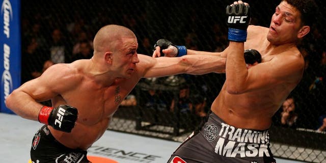 MONTREAL, QC - MARCH 16: (L-R) Georges St-Pierre punches Nick Diaz in their welterweight championship bout during the UFC 158 event at Bell Centre on March 16, 2013 in Montreal, Quebec, Canada. (Photo by Josh Hedges/Zuffa LLC/Zuffa LLC via Getty Images)