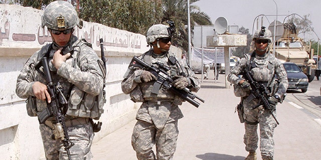 March 23: U.S. troops stand guard outside a local journalists' union office in Basra, Iraq. As the U.S. tries to move from invading power to normal diplomatic partner and the last American troops obligated to be gone by year's end, the protection of American diplomats will fall almost entirely to private contractors and Iraqi security forces.