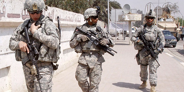 March 23: U.S. troops stand guard outside a local journalists' union office in Basra, Iraq. As the U.S. tries to move from invading power to normal diplomatic partner and the last American troops obligated to be gone by year's end, the protection of American diplomats will fall almost entirely to private contractors and Iraqi security forces.
