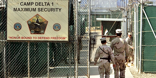In this file photo from June 27, 2006, reviewed by a U.S. Department of Defense official, U.S. military guards walk within Camp Delta military-run prison, at the Guantanamo Bay U.S. Naval Base, Cuba.