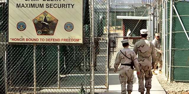In this file photo from June 27, 2006, reviewed by a U.S. Department of Defense official, U.S. military guards walk within Camp Delta military-run prison, at the Guantanamo Bay U.S. Naval Base, Cuba.