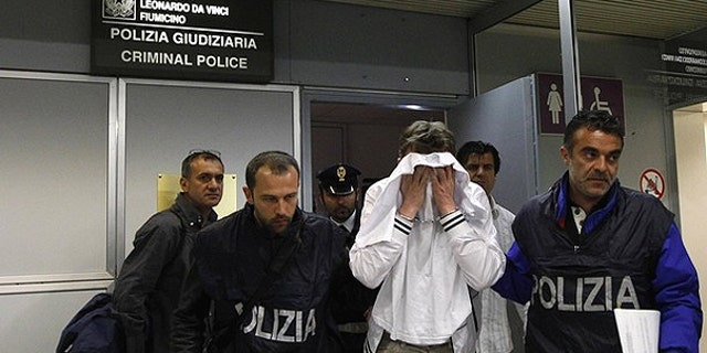 April 25: A man (in white) from Kazakhstan is escorted by police as he leaves Fiumicino airport, northeast Rome. The man, using a knife, tried to hijack an Alitalia flight from Paris to Rome on Sunday night, demanding it be flown to Libya, but was quickly overpowered and arrested when the plane landed, officials and witnesses said.