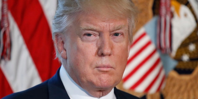President Donald Trump listens as Treasury Secretary Steve Mnuchin speaks at the Treasury Department in Washington, Friday, April 21, 2017. (AP Photo/Alex Brandon)