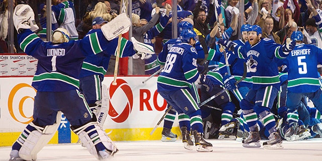 April 26: Vancouver Canucks' Roberto Luongo, left, skates to join Raffi Torres, right, and the rest of the team as they celebrate after defeating the Chicago Blackhawks in overtime during game 7 of an NHL Western Conference quarterfinal Stanley Cup playoff hockey series in Vancouver, British Columbia.