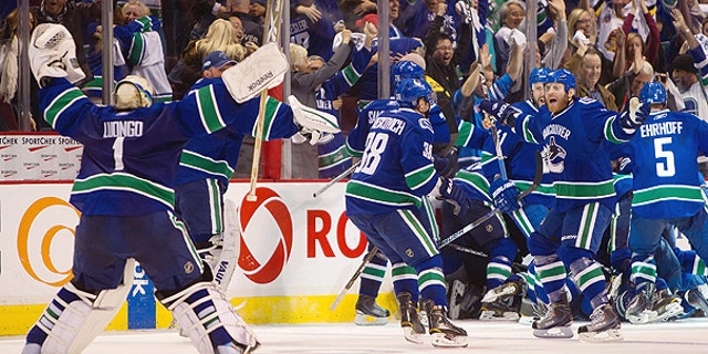 April 26: Vancouver Canucks' Roberto Luongo, left, skates to join Raffi Torres, right, and the rest of the team as they celebrate after defeating the Chicago Blackhawks in overtime during game 7 of an NHL Western Conference quarterfinal Stanley Cup playoff hockey series in Vancouver, British Columbia.