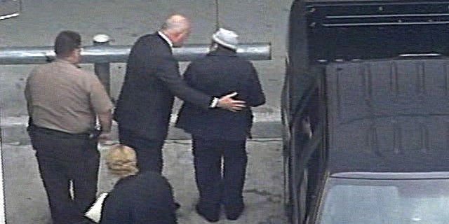 April 10, 2010: In this image from video from WSVN-TV, former Panamanian dictator Manuel Noriega, wearing hat, right, arrives at Miami International Airport in Miami to board an Air France flight to Paris.