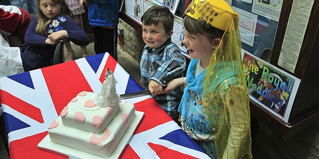 April 26: Local children Gabriel Perry, second right, aged four, and Caitlin Argles-Clarke, right, aged five, pose for photographs to cut the wedding cake after winning the best costumes awards during a 'street' party to mark the royal wedding in the town of Buckingham, England.