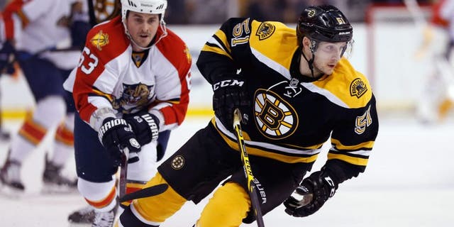 Mar 31, 2015; Boston, MA, USA; Boston Bruins center Ryan Spooner (51) keeps the puck away from Florida Panthers center Dave Bolland (63) during the first period at TD Banknorth Garden. Mandatory Credit: Greg M. Cooper-USA TODAY Sports